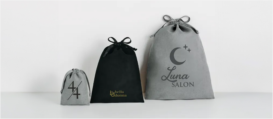 黒、グレーのスウェード巾着にロゴが印刷されたもの